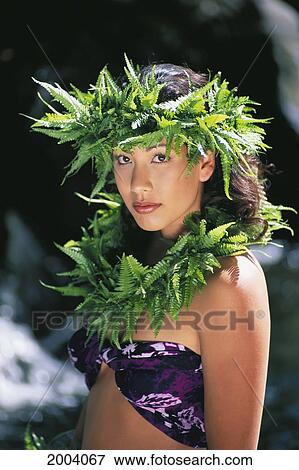 Stock Photo - Close-Up Bust Shot Of Pretty Young Woman Wearing Fern Haku And Lei, Waterfall Background. Fotosearch