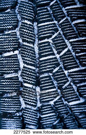 Stock Photography - Close up detail of winter tires on a car with snow clinging in the tread; Sognefjord, Norway. Fotosearch