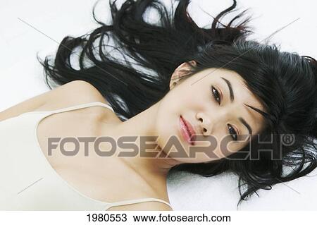 Stock Image - Close-Up Of A Beautiful Asian Woman Laying Down.. Fotosearch