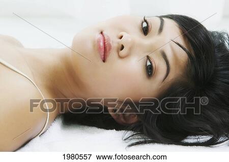 Stock Photo - Close-Up Of A Beautiful Asian Woman Laying Down.. Fotosearch