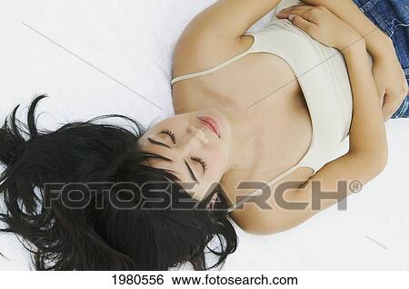 Stock Photograph - Close-Up Of A Beautiful Asian Woman Laying Down.. Fotosearch