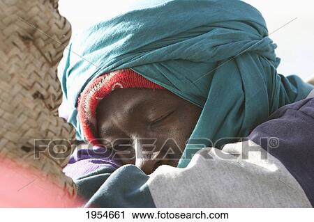 Stock Image - Close-up of a man resting with eyes closed, Mali. Fotosearch