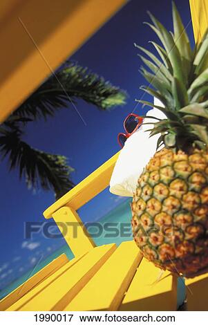 Close-Up Of A Pineapple, White Towel And Pink Glasses On Beach Chair, Blue Sky, Tilted Image View Large Photo Image Stock Photo - Close-Up Of A Pineapple, White Towel And Pink Glasses On Beach Chair, Blue Sky, Tilted Image. Fotosearch