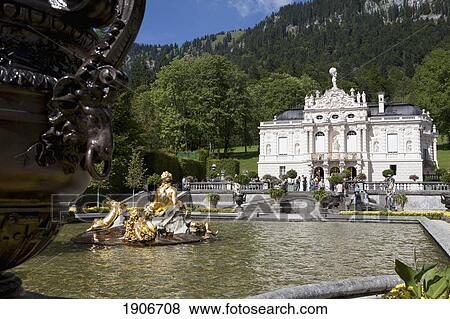 Stock Photo - Close Up Of A Vase With A Pond, Gold Fountain And White Castle In The Background; Linderhof, Germany. Fotosearch