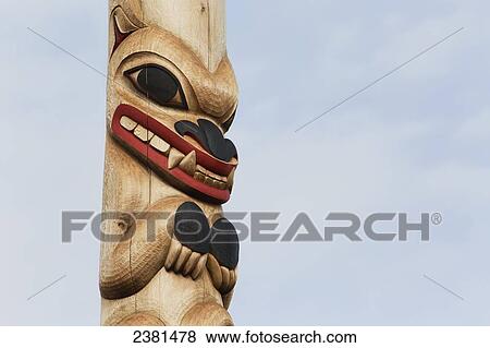 Stock Photo - Close up of an animal carved and painted on a totem pole; Whitehorse, Yukon, Canada. Fotosearch