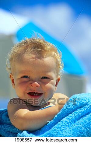 Stock Photo - Close-Up Of Baby Boy Wrapped In Towel Smiling B1033. Fotosearch