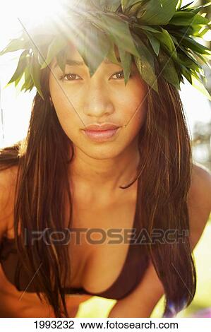 Stock Image - Close-Up Of Beautiful Hawaiian Girl Wearing Haku Lei, Sunburst. Fotosearch