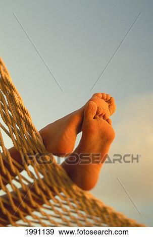 Close-Up Of Bottom Woman's Feet Crossed, Hammock With Golden Afternoon Light, Sand View Large Photo Image Stock Photo - Close-Up Of Bottom Woman's Feet Crossed, Hammock With Golden Afternoon Light, Sand. Fotosearch