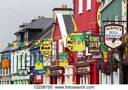 Stock Image - Close up of colourful series of houses with signs advertising bars and Bed and Breakfasts; Dingle, County Kerry, Ireland. Fotosearch