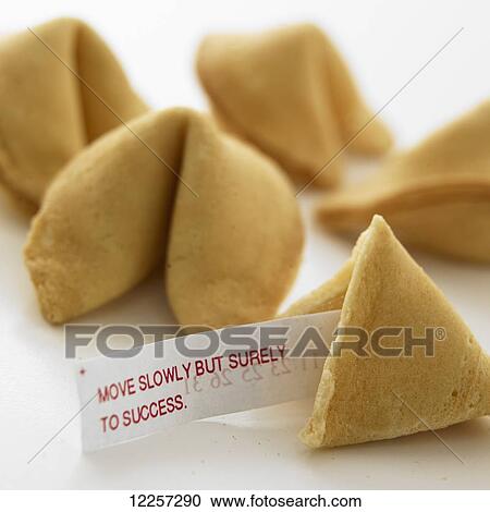 Stock Image - Close up of fortune cookies with fortune sticking out of broken cookie on white background. Fotosearch