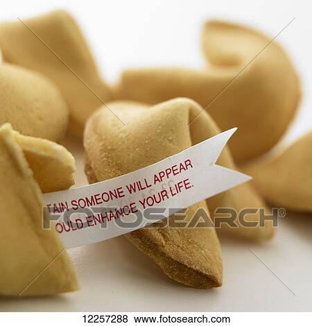 Stock Photo - Close up of fortune cookies with fortune sticking out of broken cookie on white background. Fotosearch