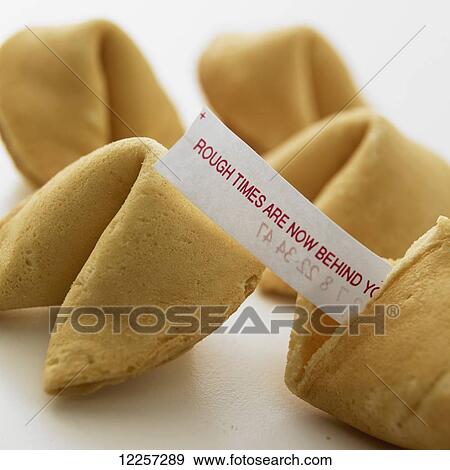 Stock Photo - Close up of fortune cookies with fortune sticking out of broken cookie on white background. Fotosearch