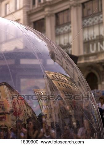 Stock Image - Close-Up Of Glass Globe With People And Buildings Reflecting In It; Rome, Italy. Fotosearch