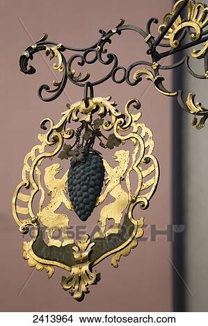 Picture - Close up of gold sign with grapes and lions; Rattenberg, Austria. Fotosearch