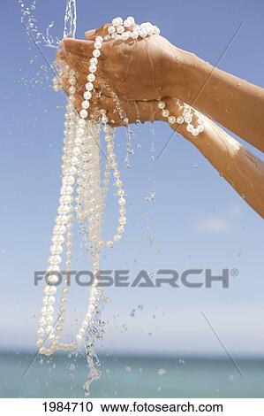 Close-Up Of Hands Holding Strings Of Pearls, Water Pouring Over Them. View Large Photo Image Stock Image - Close-Up Of Hands Holding Strings Of Pearls, Water Pouring Over Them.. Fotosearch