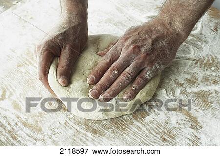 Stock Photo - Close-Up Of Hands Kneading Dough. Fotosearch