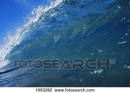 Stock Image - Close Up Of Huge, Glassy Wave, Glimpse Of Blue Sky. Fotosearch