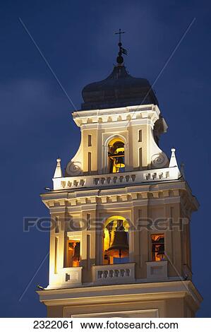 Stock Image - Close up of illuminated bell tower against evening sky; Parma, Emilia-Romagna, Italy. Fotosearch