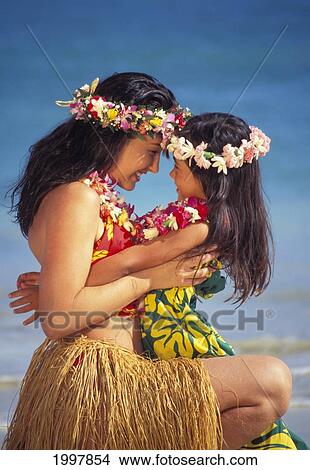 Picture - Close-Up Of Mom With Daughter In Lap, Heads Together, Smiling, Hula Oufits. Fotosearch