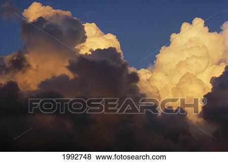 Stock Photo - Close-Up Of Puffy Clouds Tinted Pink By The Sunset.. Fotosearch