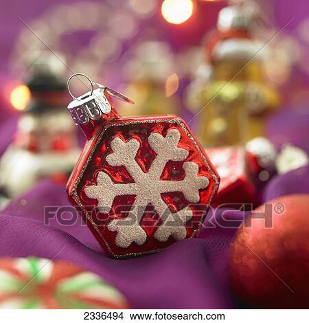 Picture - Close-Up Of Red And White Snowflake Christmas Ornament On Purple Background. Fotosearch