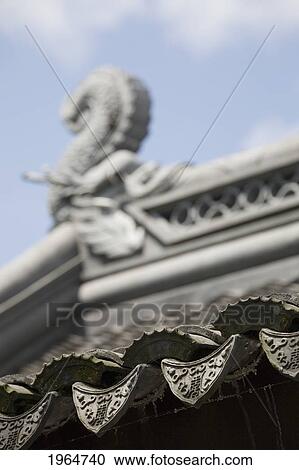 Stock Image - Close-Up Of Roof Drip Tiles With Dragonfish In The Background; Portland Oregon United States Of America. Fotosearch