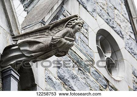 Stock Image - Close up of stone winged angel protruding from stone church; County Galway, Ireland. Fotosearch