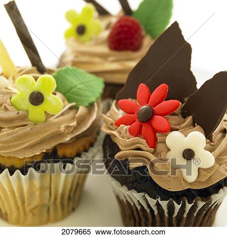Stock Photography - Close-Up Of Three Chocolate Cupcakes With Candy Flowers.. Fotosearch