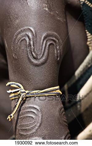 Stock Image - Close up of traditional scar decorations amongst Mursi tribal men; Makki, South Omo, Southern Nations, Ethiopia. Fotosearch