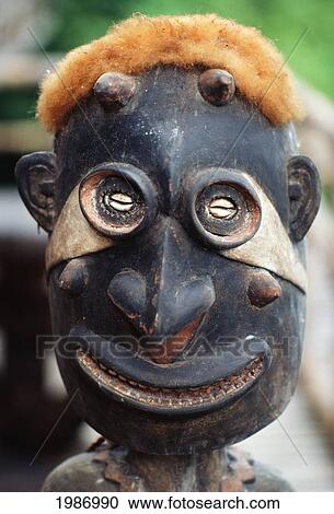 Stock Image - Close-up of wood statue with opossum fur on head; Papua New Guinea. Fotosearch