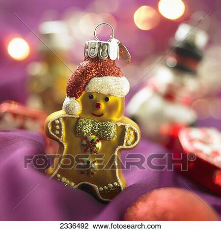 Stock Image - Close-Up Of Yellow Gingerbread Cookie Christmas Ornament On Purple Background. Fotosearch