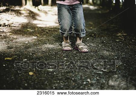 Stock Photography - Close-Up Of Young Girl's Feet In Sandals On A Forest Trail; Thetford Mines Quebec Canada. Fotosearch