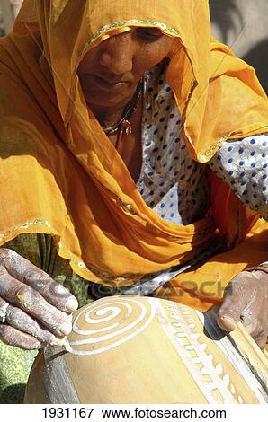Close-up on a woman in orange sari painting a terracotta pot, Nimaj, Rajasthan, India, Nimaj, Rajasthan, India. View Large Photo Image Stock Photo - Close-up on a woman in orange sari painting a terracotta pot, Nimaj, Rajasthan, India, Nimaj, Rajasthan, India.. Fotosearch