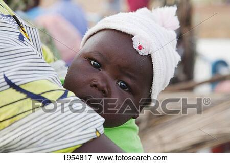 Stock Photo - Close-up portrait of a baby with mother at Bani River, Mali. Fotosearch