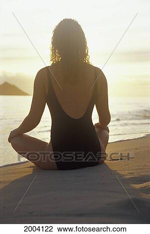 Close-Up View From Behind Woman Sitting On Beach Meditating, Facing Sunrise, Bright Sky View Large Photo Image Stock Image - Close-Up View From Behind Woman Sitting On Beach Meditating, Facing Sunrise, Bright Sky. Fotosearch