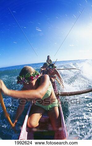 Picture - Closeup Front View Of Girls Outrigger Canoe Surfing, Afternoon, Bright Blue Sky Ocean Teenager. Fotosearch