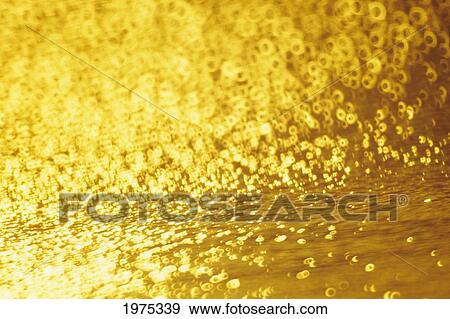 Stock Photo - Closeup Of Golden Shimmering Reflections Off Water.. Fotosearch