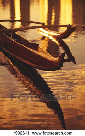 Closeup Of Koa Outrigger Canoe On Water With Reflection Of Golden Sunset. View Large Photo Image Stock Image - Closeup Of Koa Outrigger Canoe On Water With Reflection Of Golden Sunset.. Fotosearch