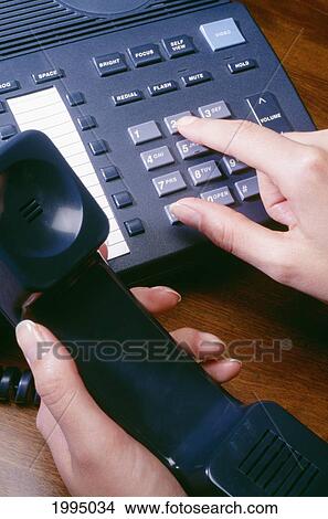 Picture - Closeup Of Womans Hand Dialing Telephone. Fotosearch