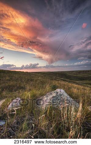 Clouds Lit At Sunset With Some Glacial Erratics Lying In Grasslands National Park; Saskatchewan Canada View Large Photo Image Stock Photo - Clouds Lit At Sunset With Some Glacial Erratics Lying In Grasslands National Park; Saskatchewan Canada. Fotosearch