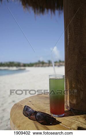 Stock Image - Cocktail Drink And Sunglasses On Beach Table At Mayan Riviera, Yucatan Peninsular, Quintana Roo State, Mexico. Fotosearch