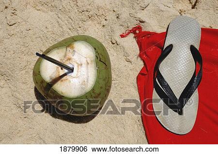 Stock Photograph - Coconut Drink And Flip Flop On Beach, Close Up. Fotosearch
