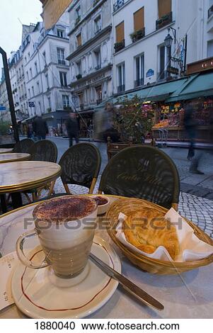 Stock Image - Coffee And Croissant At Table On Pavement At Cafe On Rue Montorgueil Early In The Morning.. Fotosearch
