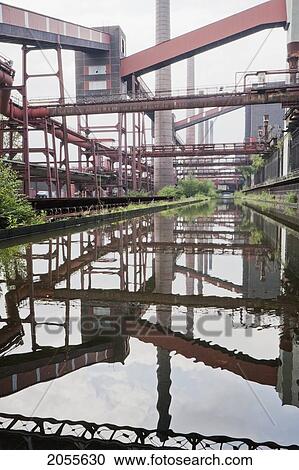 Stock Image - Coke Ovens Reflected In The Pool Of The Zollverein Coking Plant, Essen, North Rhine-Westphalia, Germany. Fotosearch