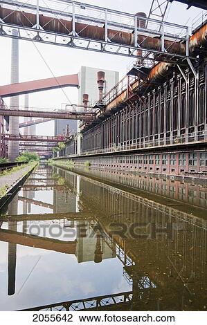 Stock Image - Coke Ovens Reflected In The Pool Of The Zollverein Coking Plant, Essen, North Rhine-Westphalia, Germany. Fotosearch