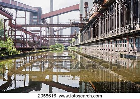 Stock Photograph - Coke Ovens Reflected In The Pool Of The Zollverein Coking Plant, Essen, North Rhine-Westphalia, Germany. Fotosearch