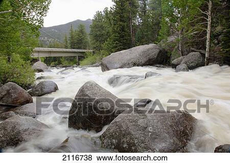 Colorado, Rocky Mountains, A bridge over a raging river with lush foliage. View Large Photo Image Stock Photo - Colorado, Rocky Mountains, A bridge over a raging river with lush foliage.. Fotosearch