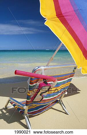 Stock Image - Colorful Beach Chair, Umbrella And Snorkel On Shore Close-Up With Ocean, Blue Sky Background. Fotosearch