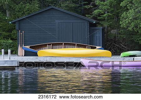 Colorful Canoes On A Cottage Dock And Reflected In The Water At Algonquin Park; Ontario Canada View Large Photo Image Stock Image - Colorful Canoes On A Cottage Dock And Reflected In The Water At Algonquin Park; Ontario Canada. Fotosearch