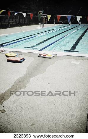 Stock Image - Colorful flotation devices at the edge of a public swimming pool; Otterburn Park, Quebec, Canada. Fotosearch